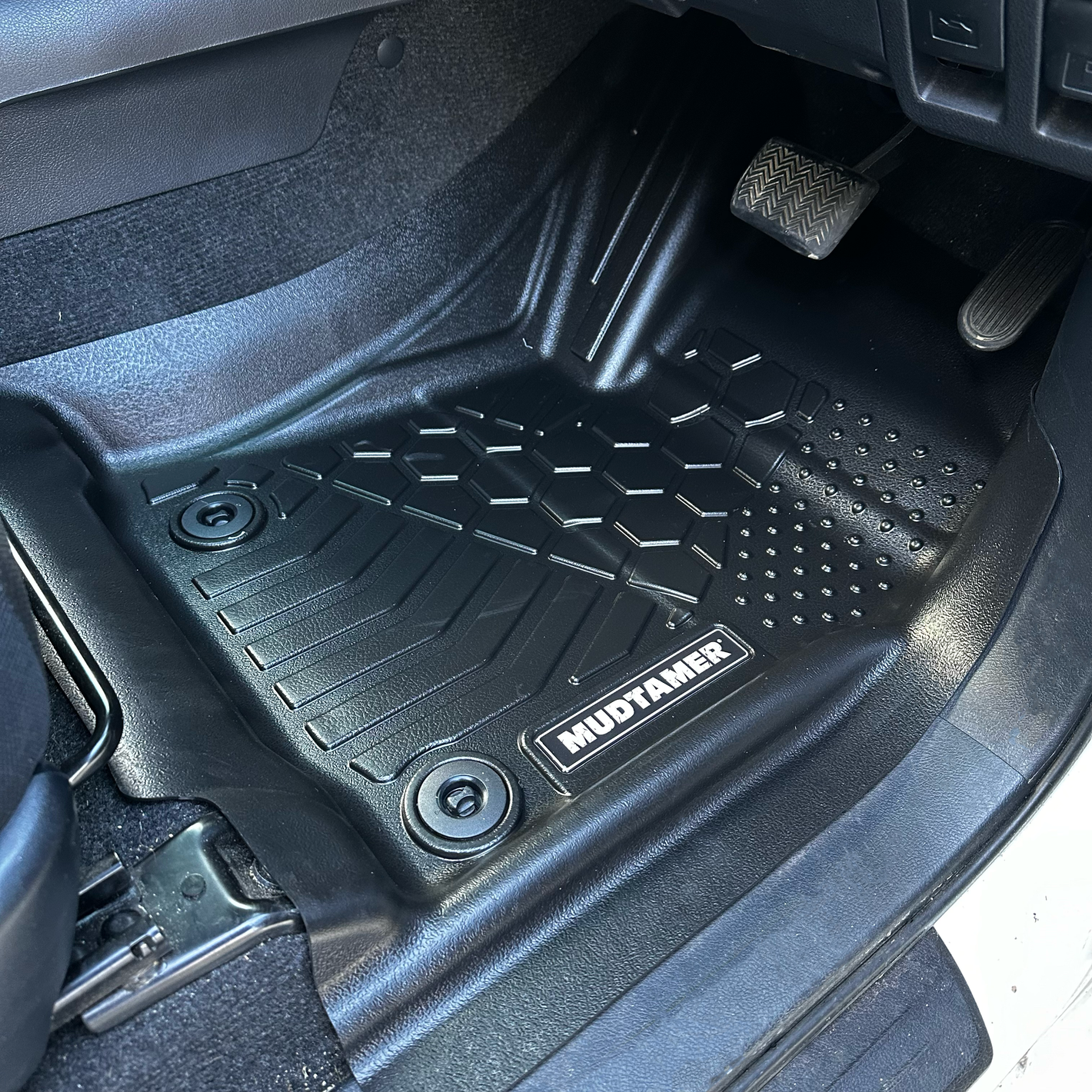 A MUDTAMER mat installed in a vehicle
