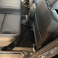 Black TPE floor mats installed in the rear of a vehicle, shown between grey seats.